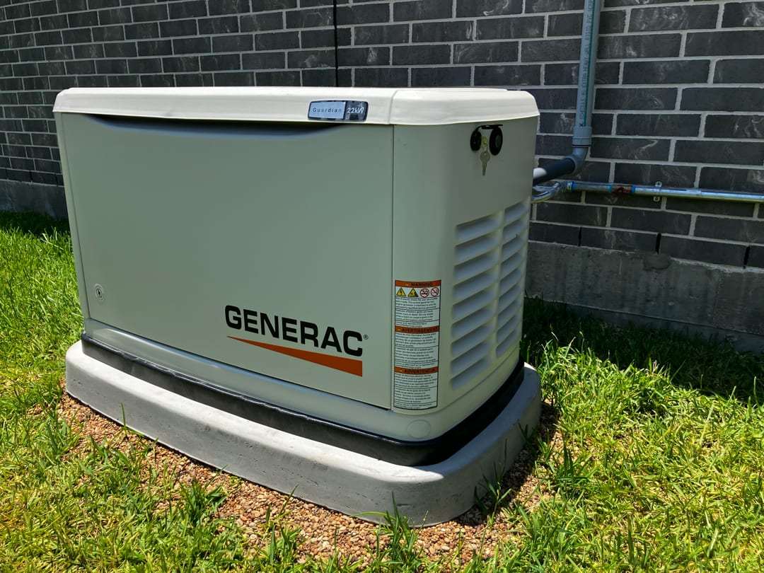 A completed Generac air-cooled standby generator installation beside a Fort Bend County home, connected and commissioned